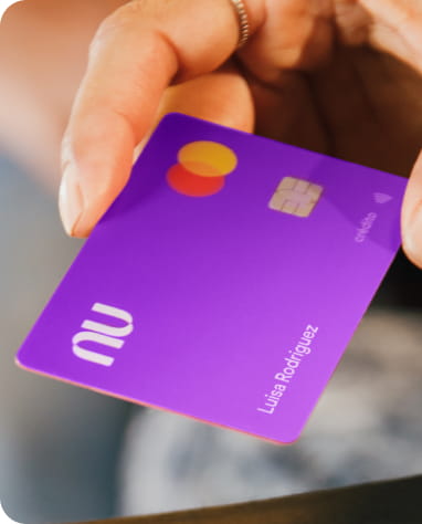 Mano sosteniendo una tarjeta morada Mastercard, lista para realizar pagos y transacciones seguras.