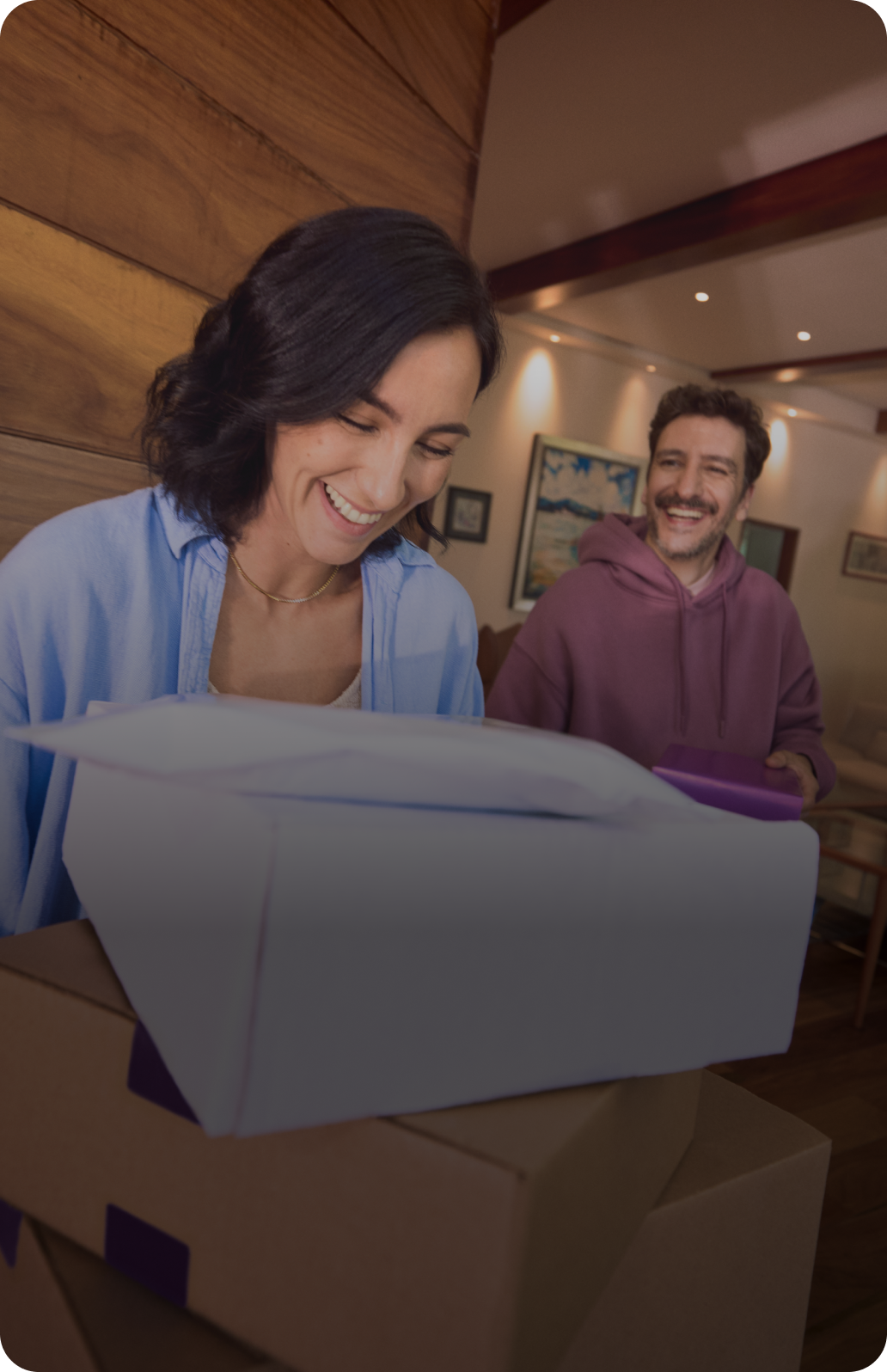 Una persona sonriendo mientras sostiene una tarjeta morada